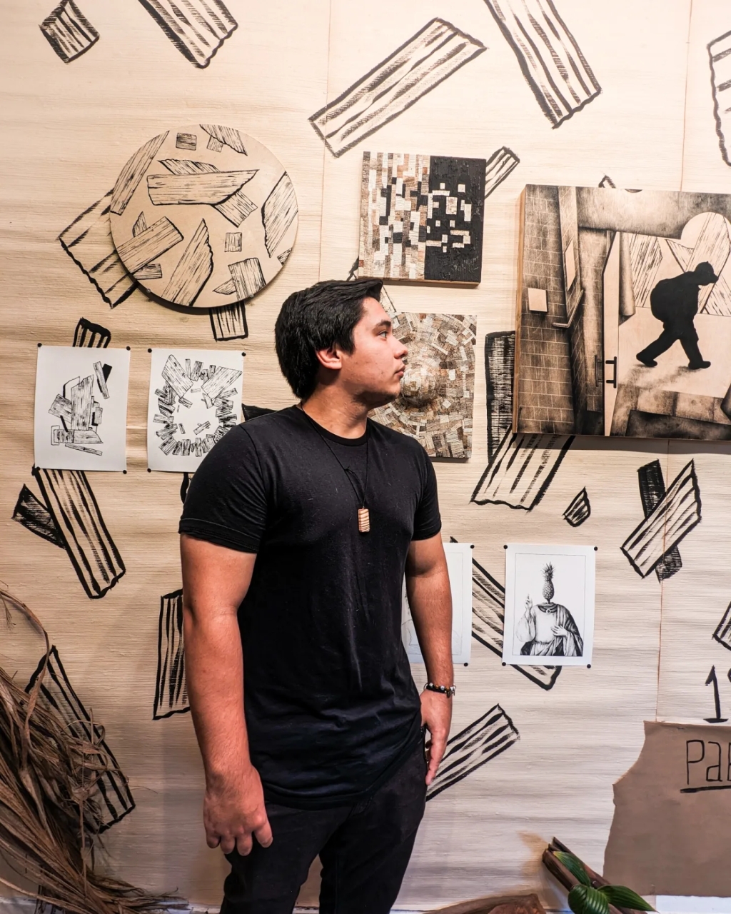 Pablo Mutate stands with his artwork made with charcoal and recycled palm stems used for his Open Studio and created during his residency at Miami Artists Nonprofit Residency Rainbow Oasiiis